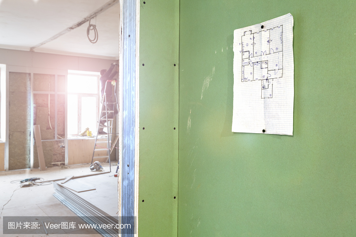 本工程在墙面和建筑工人安装石膏板干墙的公寓正在施工、改造、翻新、扩建、修复和重建。